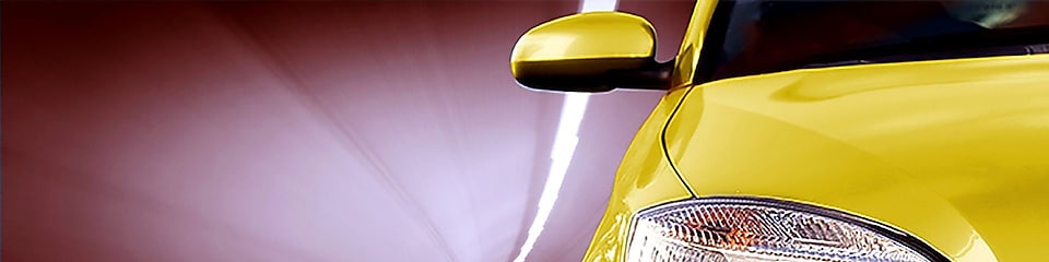 Widok z przodu żółtego samochodu jadącego tunelem, prawy przedni reflektor i lusterko wsteczne