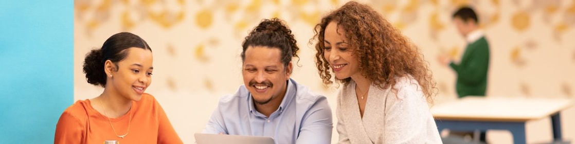 Team collaboration around a laptop in a modern office setting