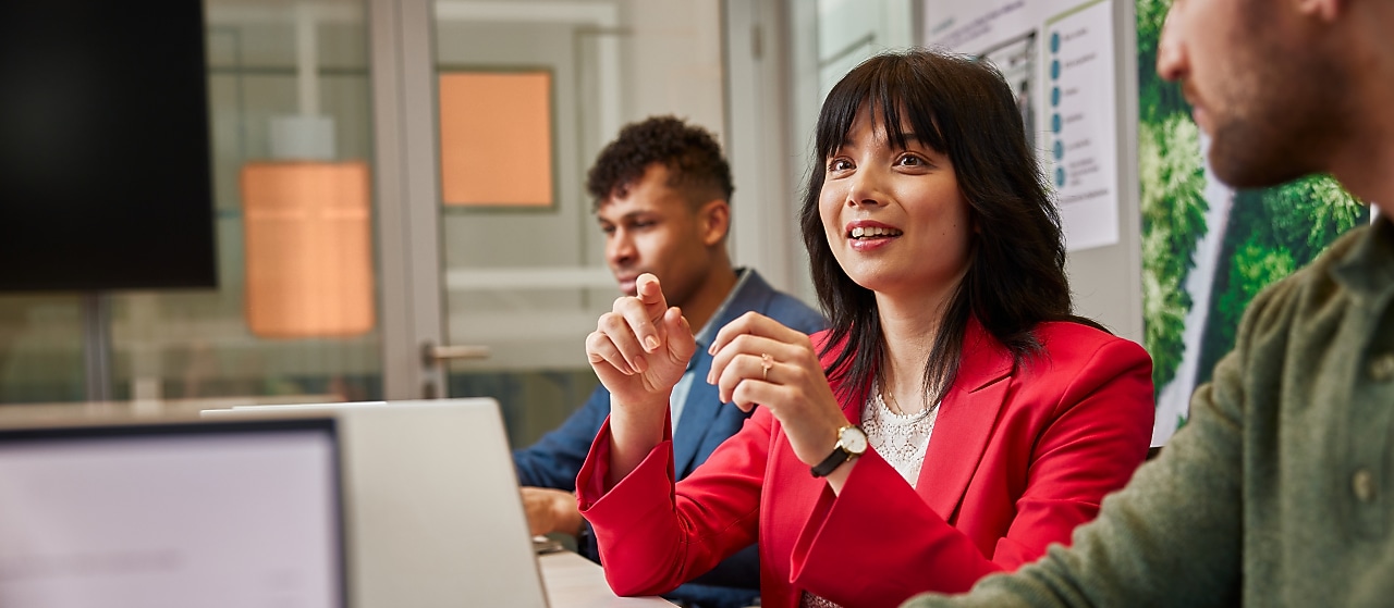 The image focuses on a female employee speaking in a meeting.