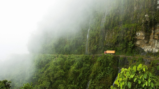 Yellow truck moving along the mountains