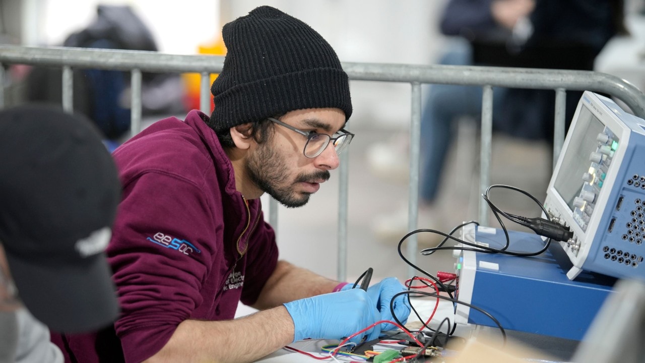 student naprawiający część elektryczną