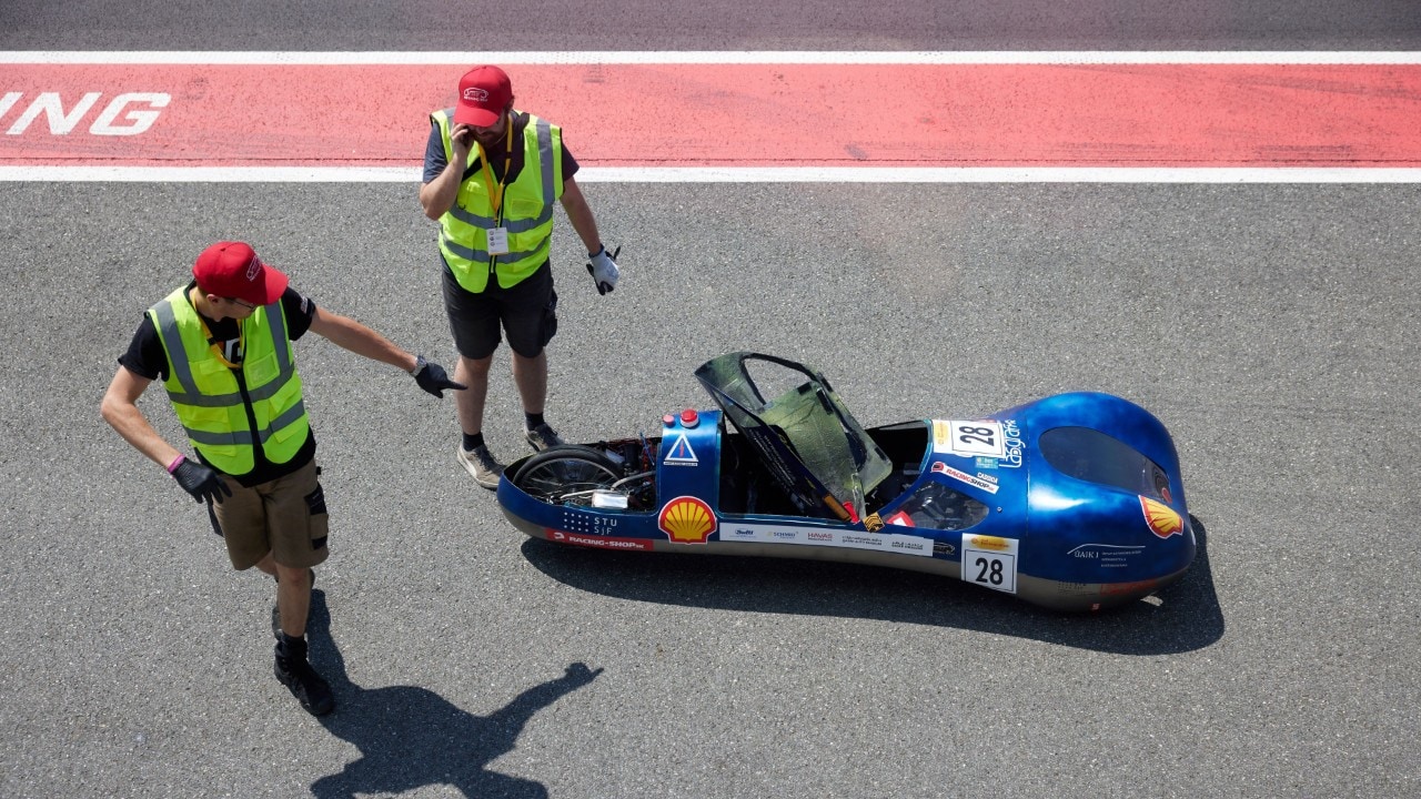 dwóch pracowników technicznych sprawdza bolid