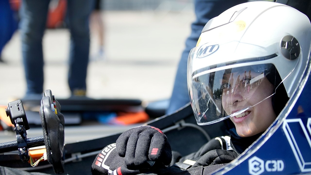 studentka w kasku za kierownica bolidu