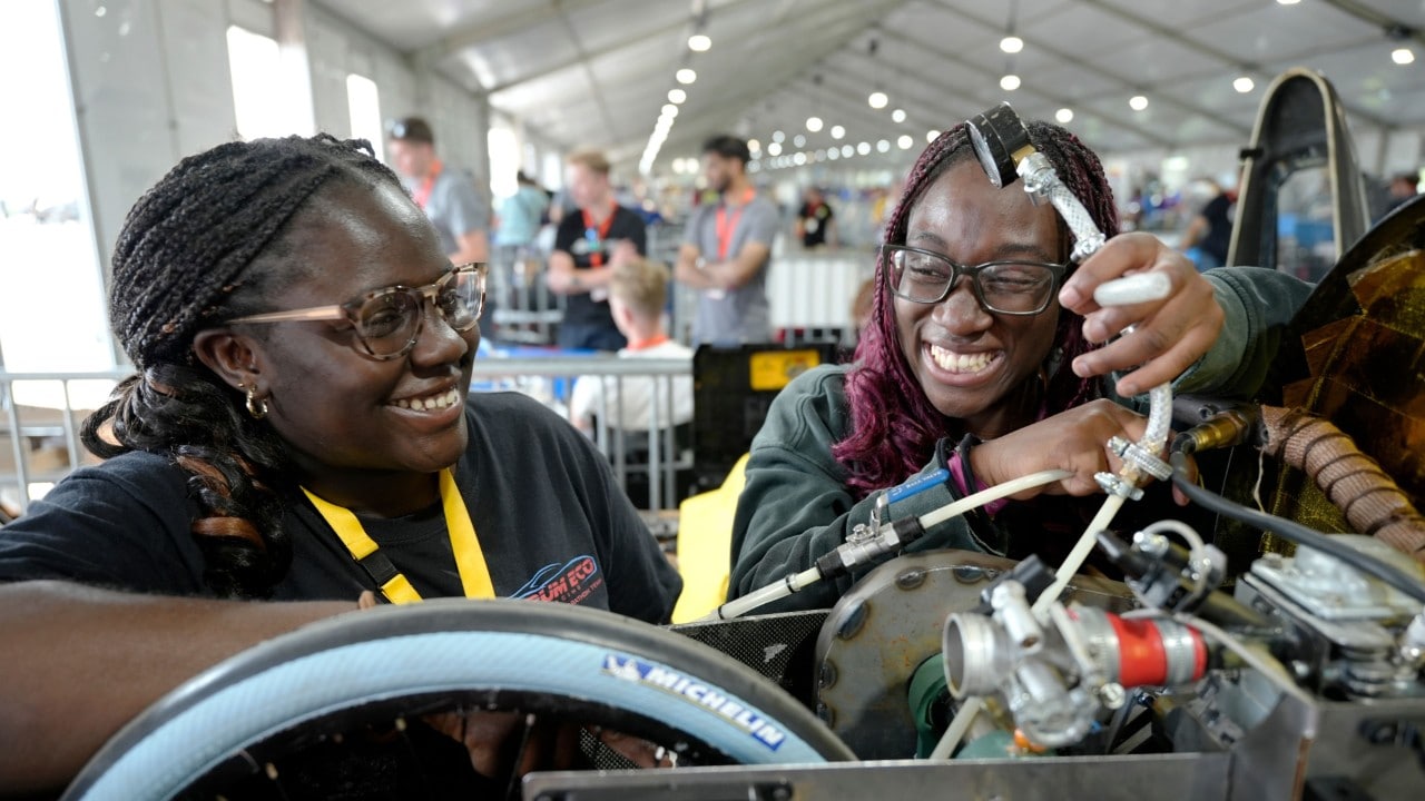 studenci w okularach ochronnych uzupełniają zboiornik z paliwem 