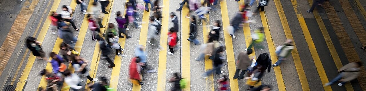 Przechodnie przechodzą przez ruchliwą ulicę w Hong Kongu