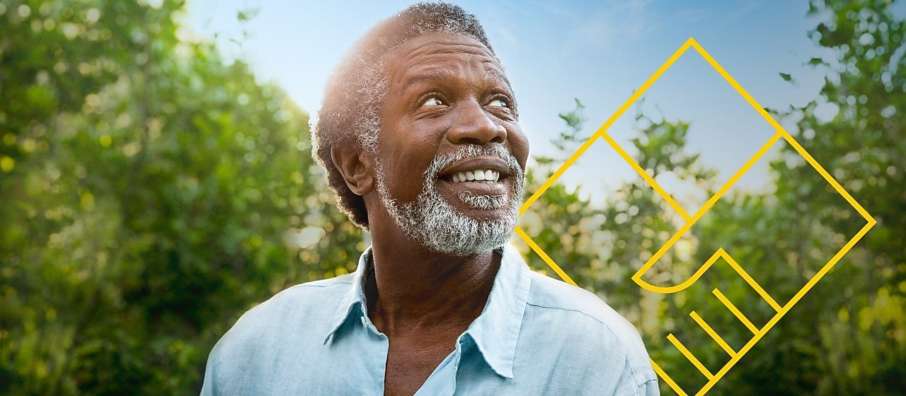 Uśmiechnięty, brodaty mężczyzna na linii lasu z zarysem ilustracji „Generowanie wartości dodanej dla akcjonariuszy”