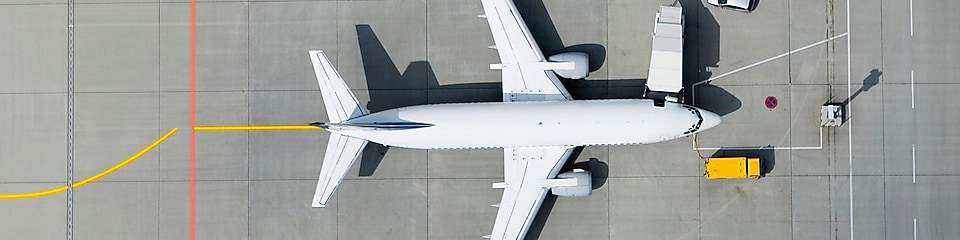 Samolot z samochodami dostawczymi na plycie lotniska widziany z lotu ptaka
