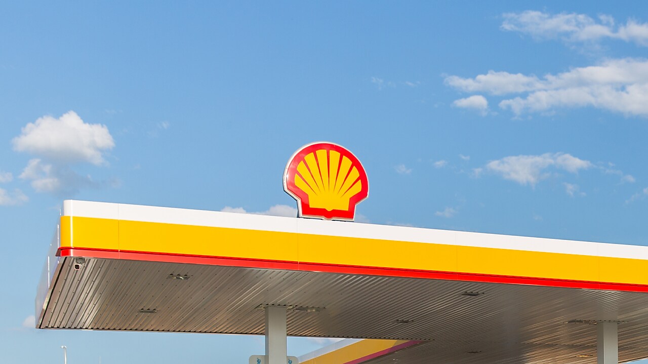 pracownik Shell na tle stacji