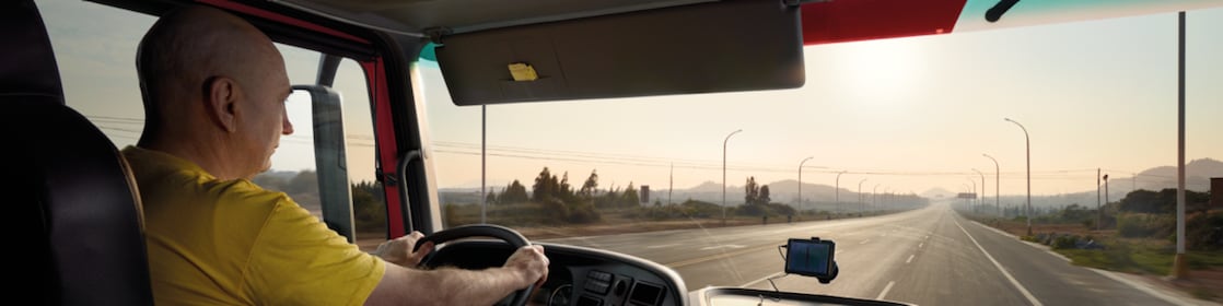kierowca ciężarówki prowadzący pojazd na pustej drodze