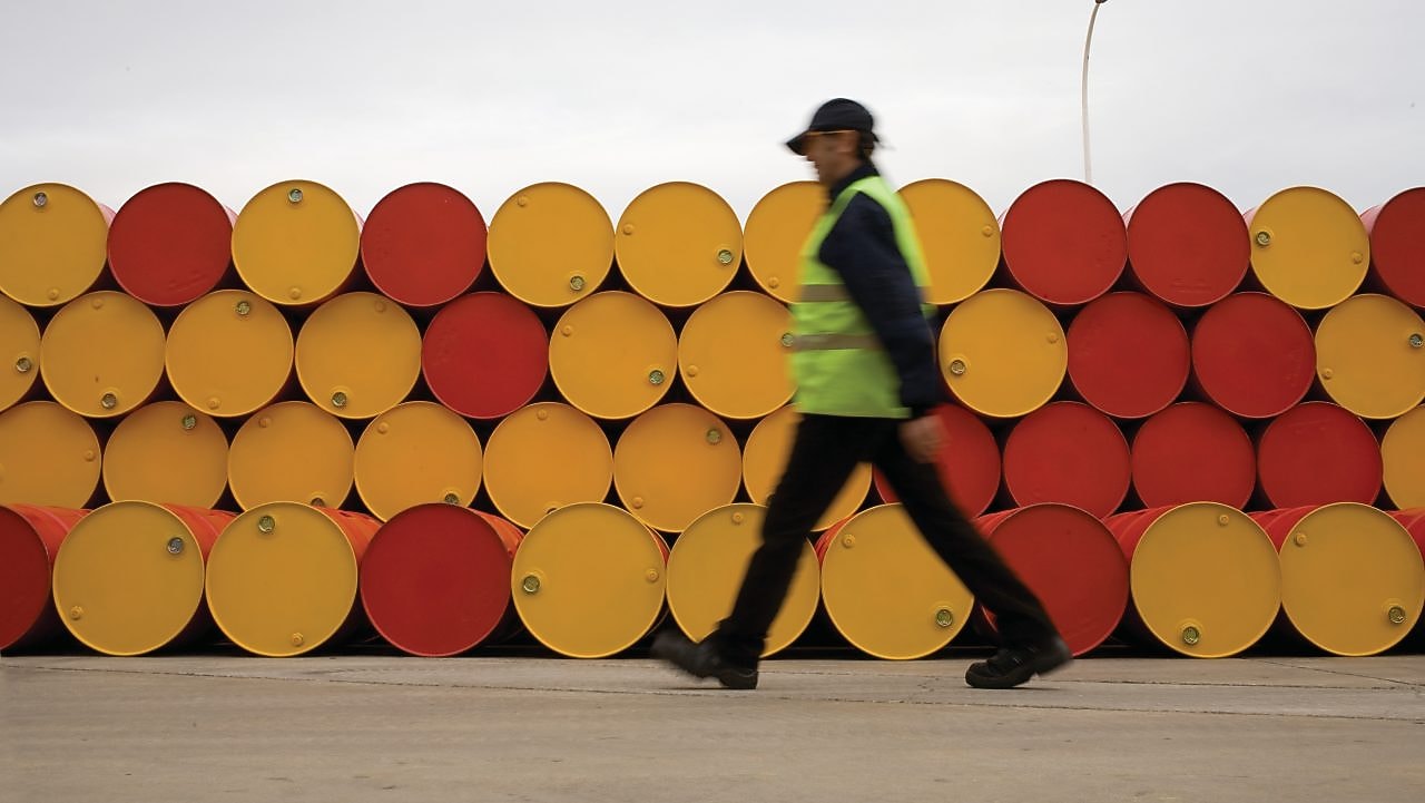 man walking barrels lubricants