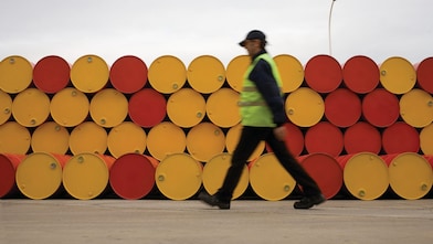 man walking barrels lubricants