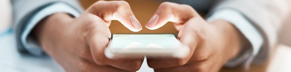 Two hands shown using a mobile device to send an email