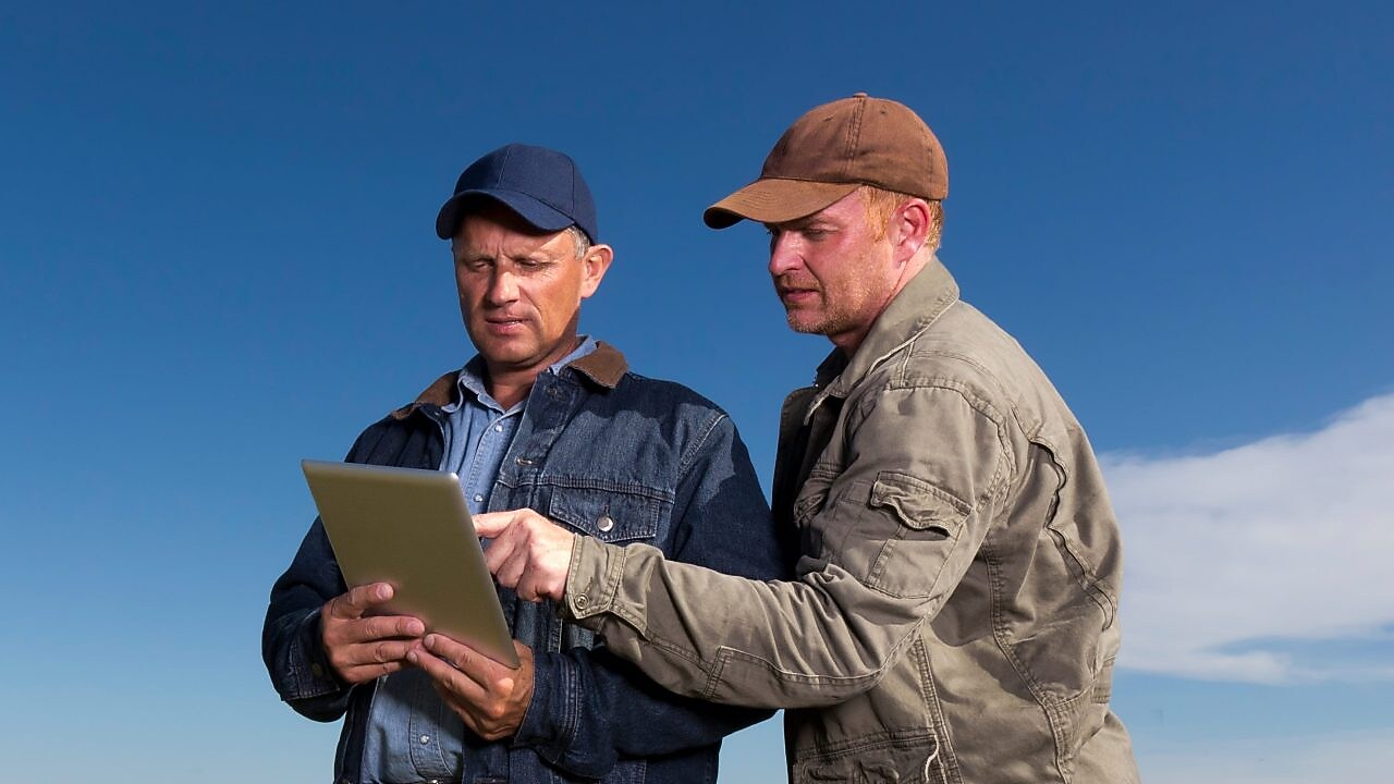 Dwóch rolników patrzących na tablet