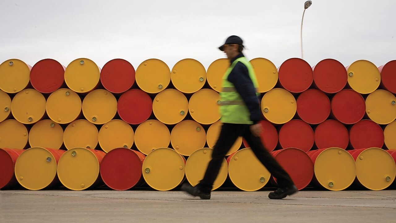 man walking barrels lubricants