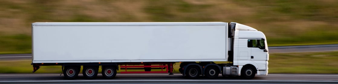 Ciężarówka na autostradzie, rozmazany ruch, widać ciężarówkę jadącą drogą.
