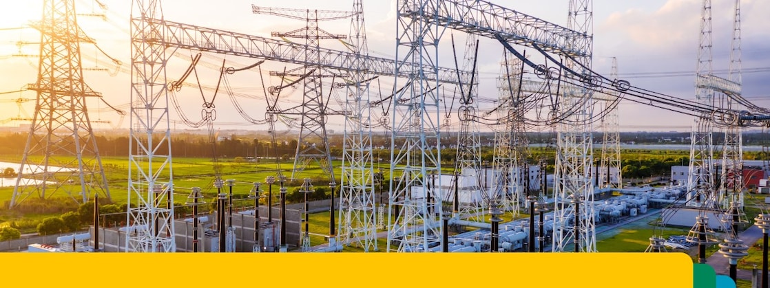 Podstacja elektroenergetyczna z siecią linii wysokiego napięcia i urządzeniami na tle zachodzącego słońca