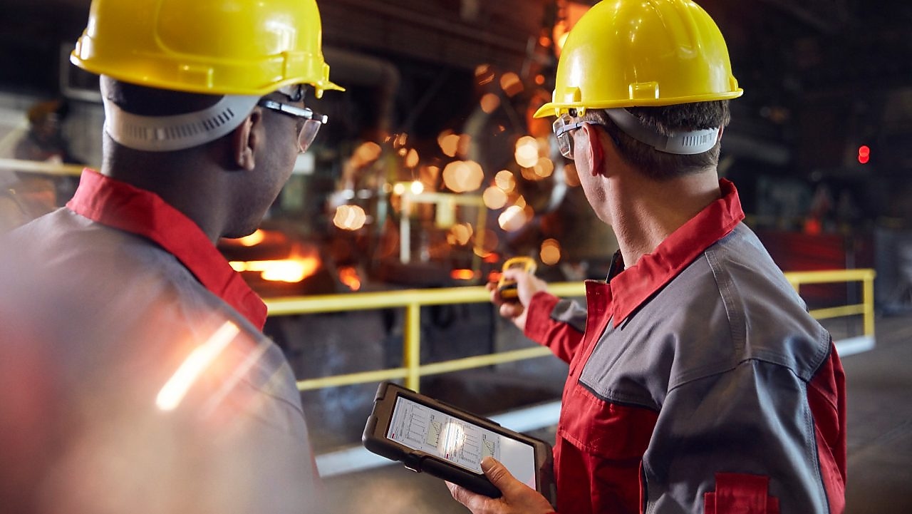 Pracownicy przemysłowi analizujący operacje w zakładzie