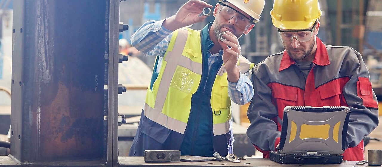 Pracownik Shell udzielający konsultacji pracownikowi przemysłowemu w zakładzie