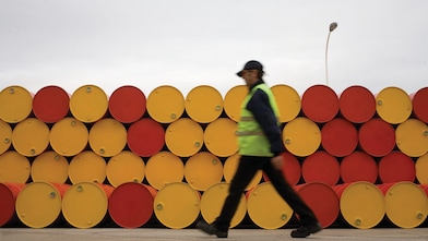 man walking barrels lubricants
