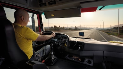 kierowca ciężarówki prowadzący pojazd na pustej drodze