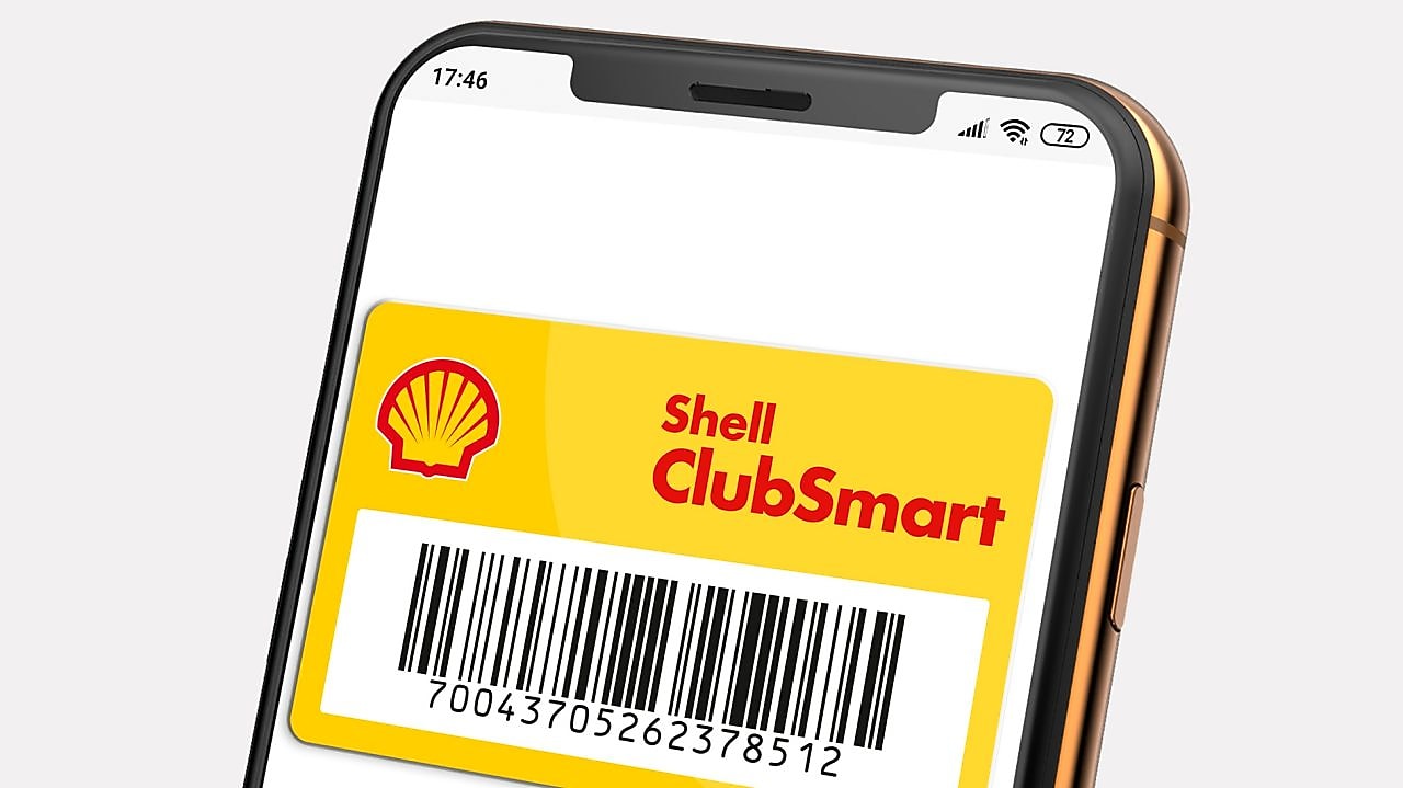 para przed stacją Shell, kobieta trzyma w ręku kartę Shell ClubSmart