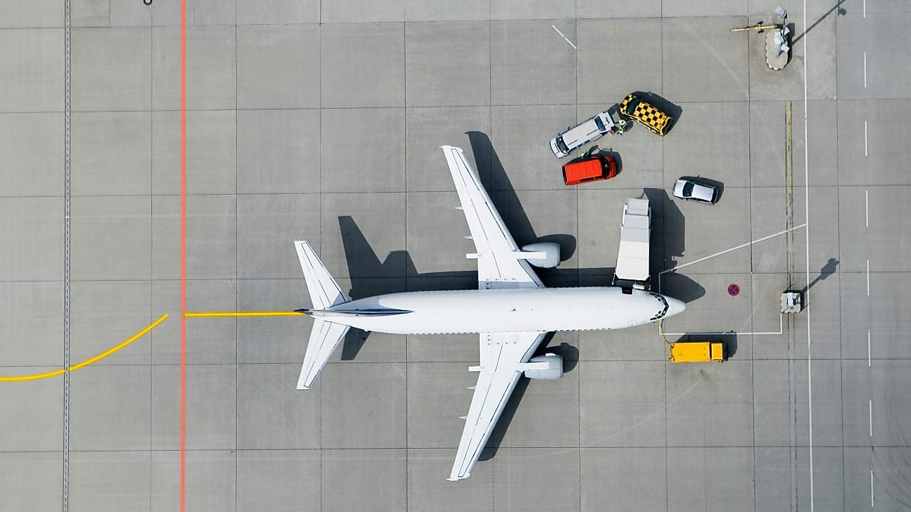 Samolot z samochodami dostawczymi na plycie lotniska widziany z lotu ptaka