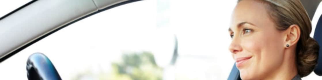 woman driving a car while smiling