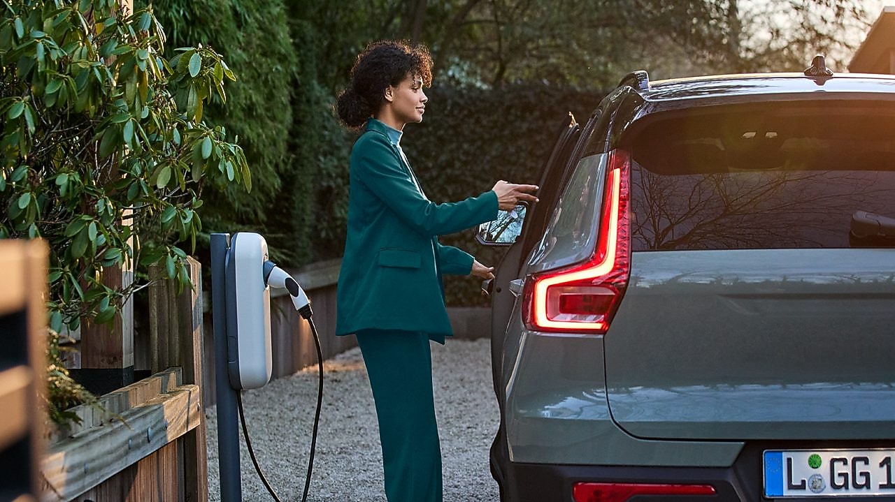 Kobieta zamierza naładować swój elektryczny samochód.