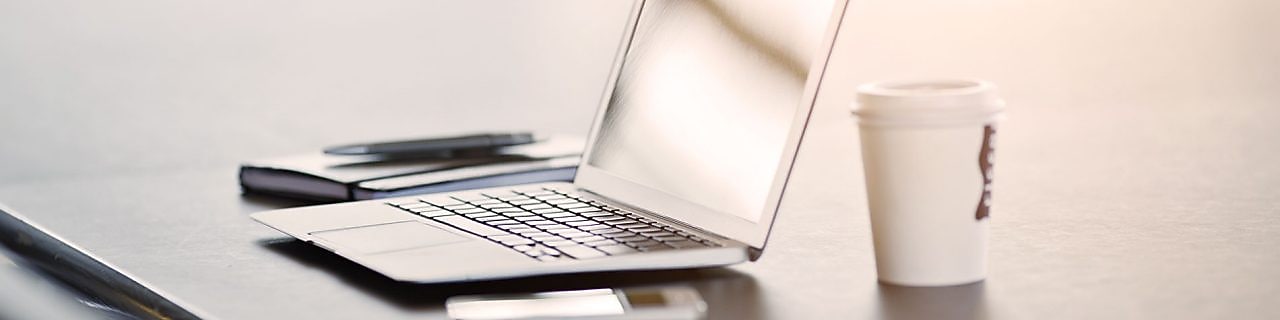 laptop, telefon komórkowy i kawa na biurku