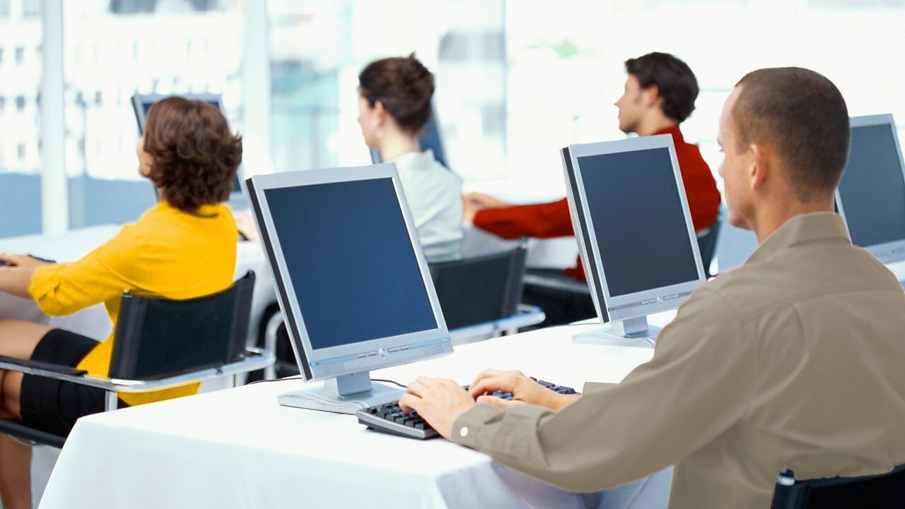 Grupa ludzi przed monitorami