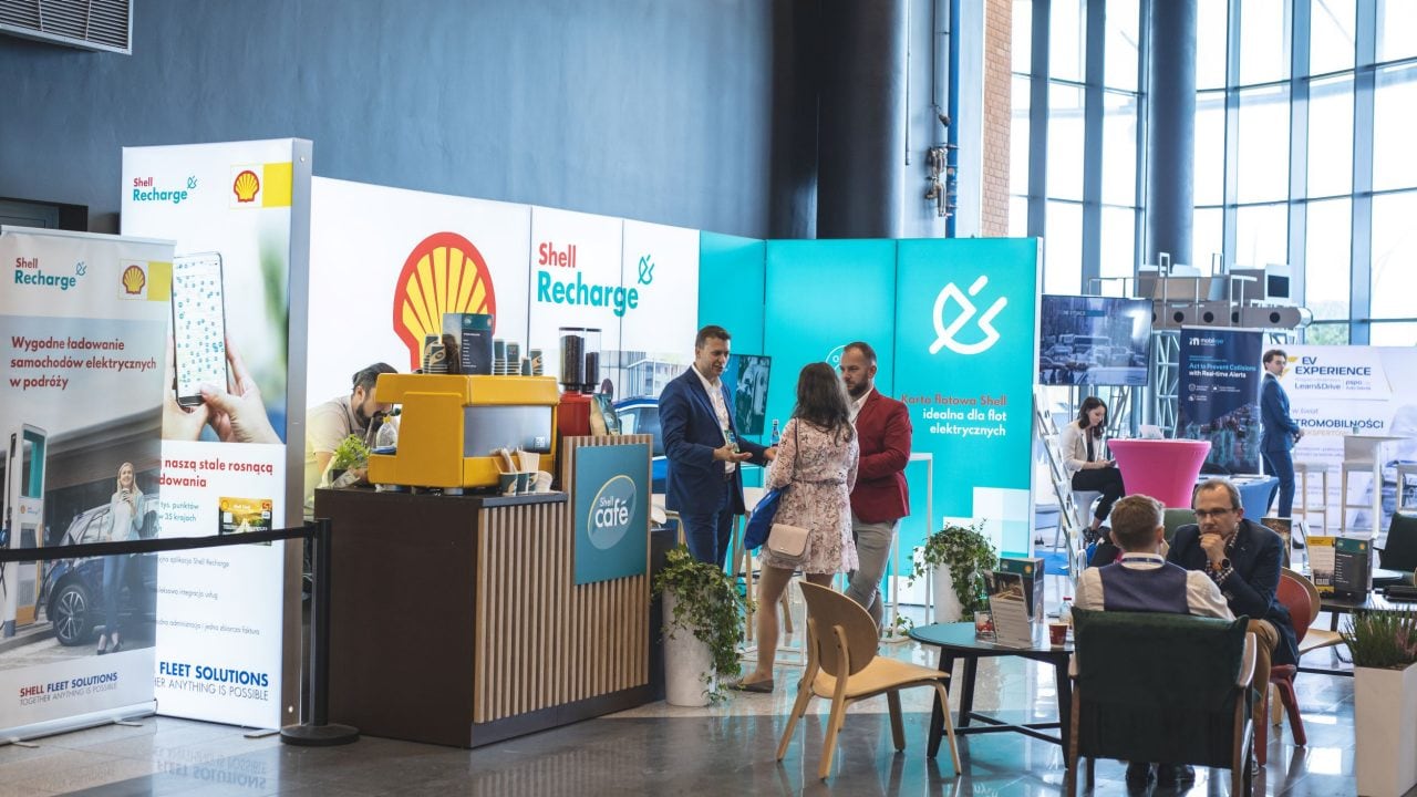 Ludzie rozmawiający ze sobą na stoisku na konferencji