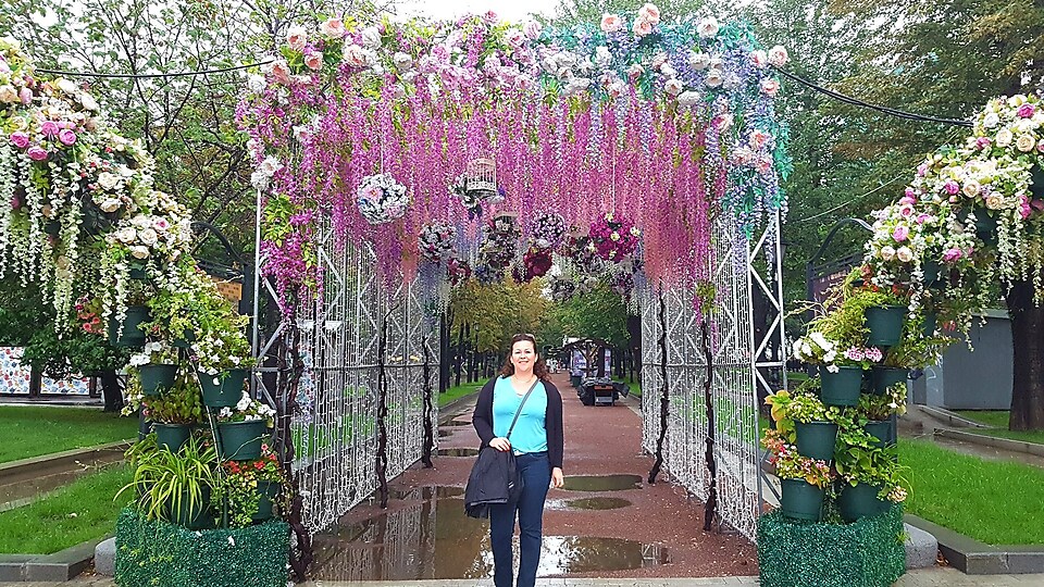 Krisztina standing under a flower arch