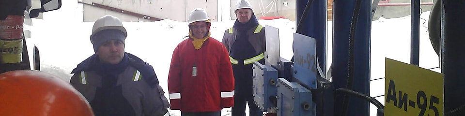 Krisztina dressed in safety gear at a 3rd party terminal with a local manager and driver