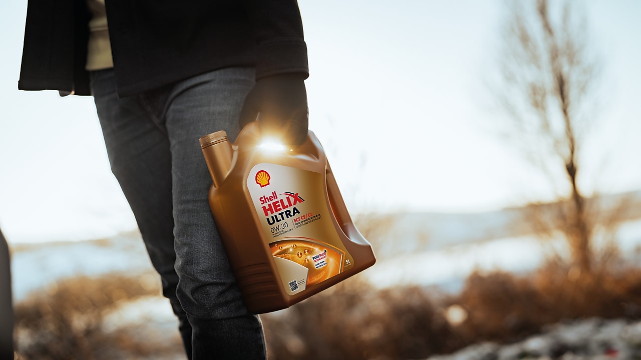 Ktoś trzymający butelkę Shell Helix Ultra OW 30