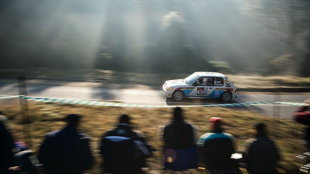 Samochód wyścigowy jadący drogą przed tłumem widzów