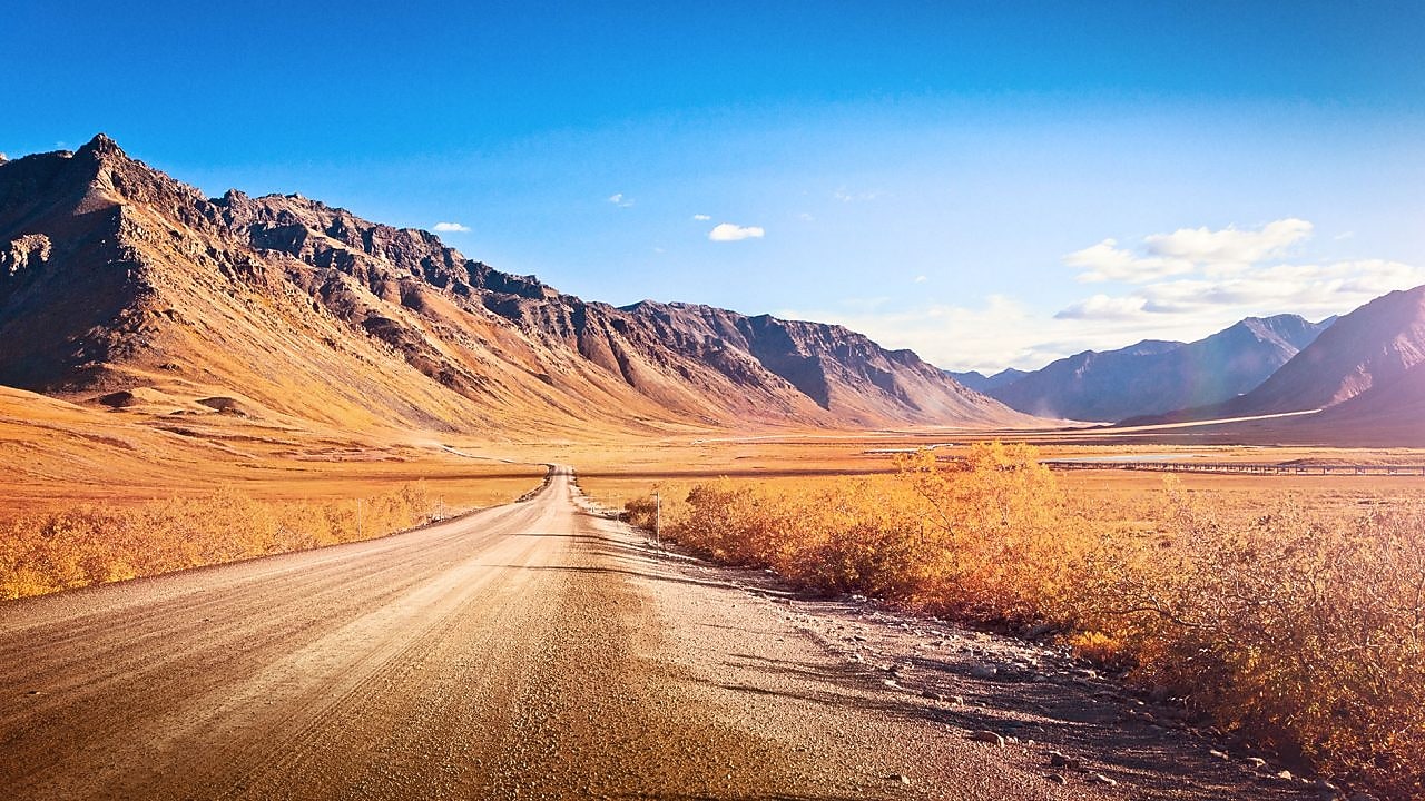 Pusta droga żwirowa w otoczeniu gór
