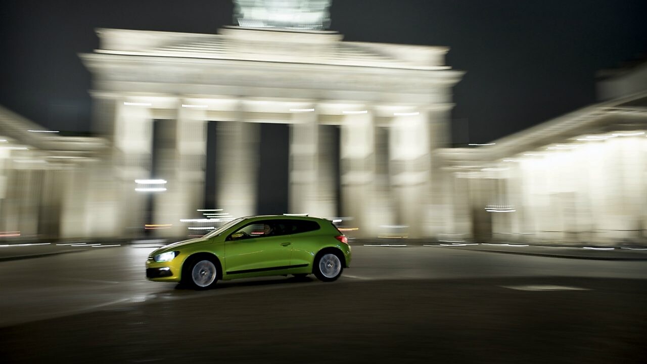 mknący ulicami zielony samochód nocą