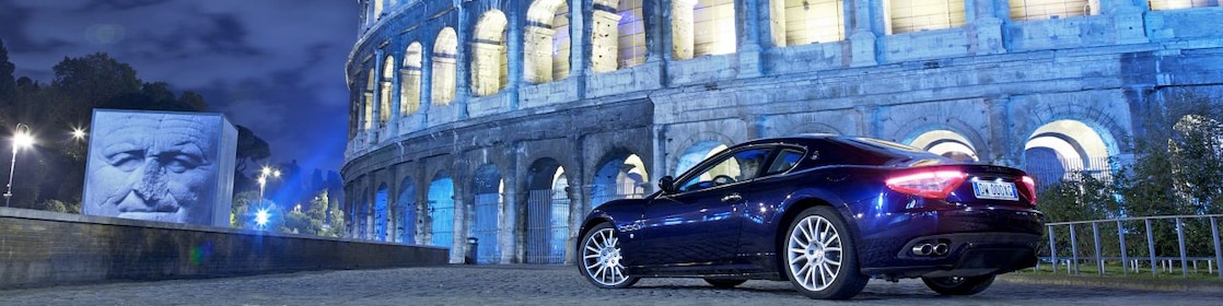 Samochód zaparkowany nocą przed Koloseum w Rzymie