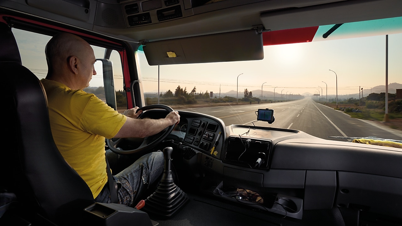 kierowca ciężarówki prowadzący pojazd na pustej drodze