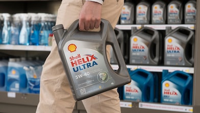 Mężczyzna trzyma w ręku opakowanie oleju Shell