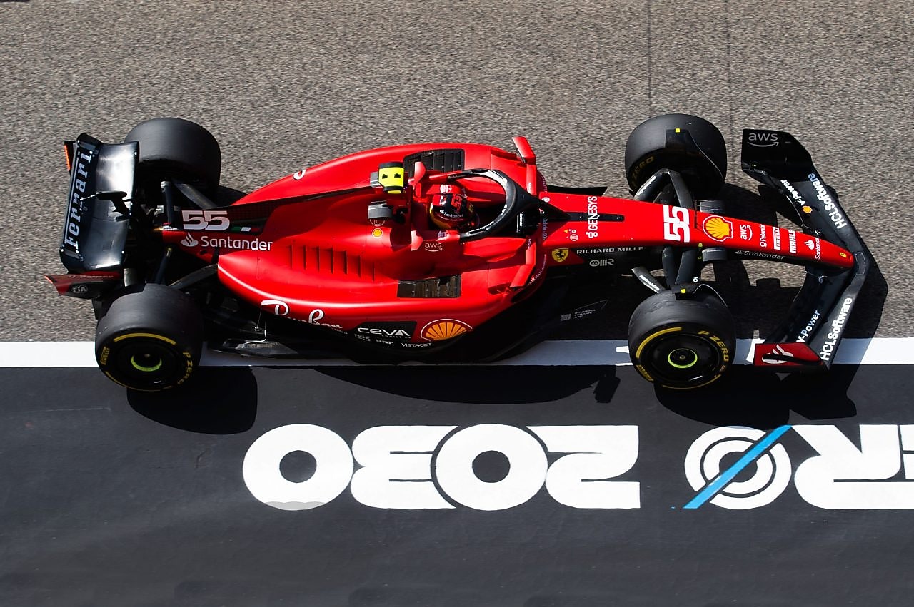 Czerwone Scuderia Ferrari stoi na torze wyścigowym - przykład innowacyjnej współpracy z Shell Helix Ultra