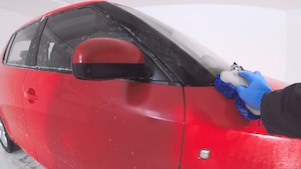 Ręka myjąca czerwony samochód z zewnątrz