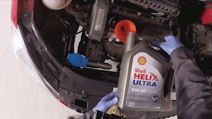 Ręce wlewające świeży olej Shell Helix Ultra