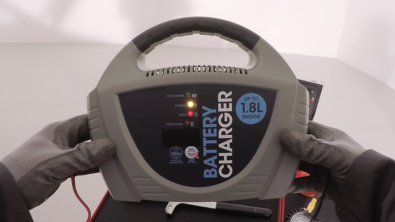 Ręce trzymające ładowarkę do akumulatorów