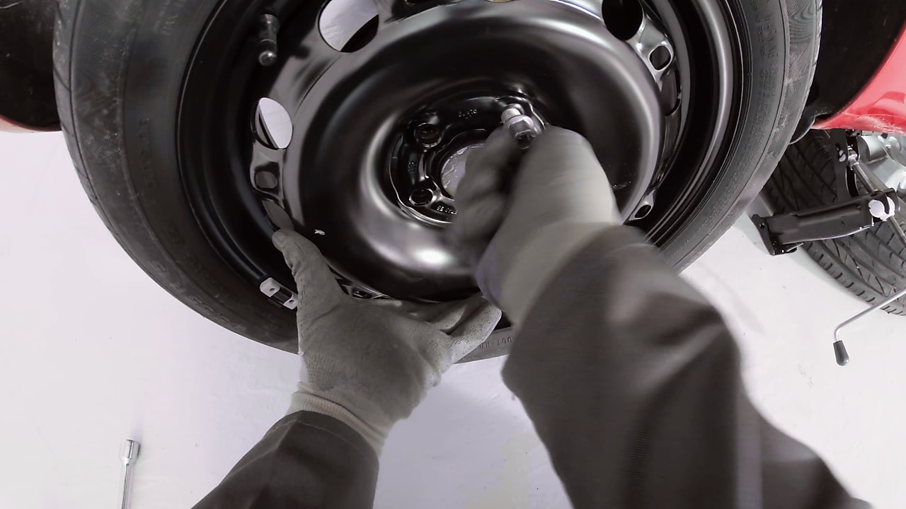 Ręce przykręcające śruby koła