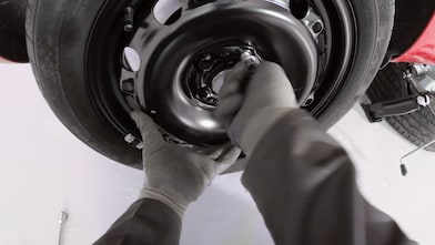 Ręce przykręcające śruby koła