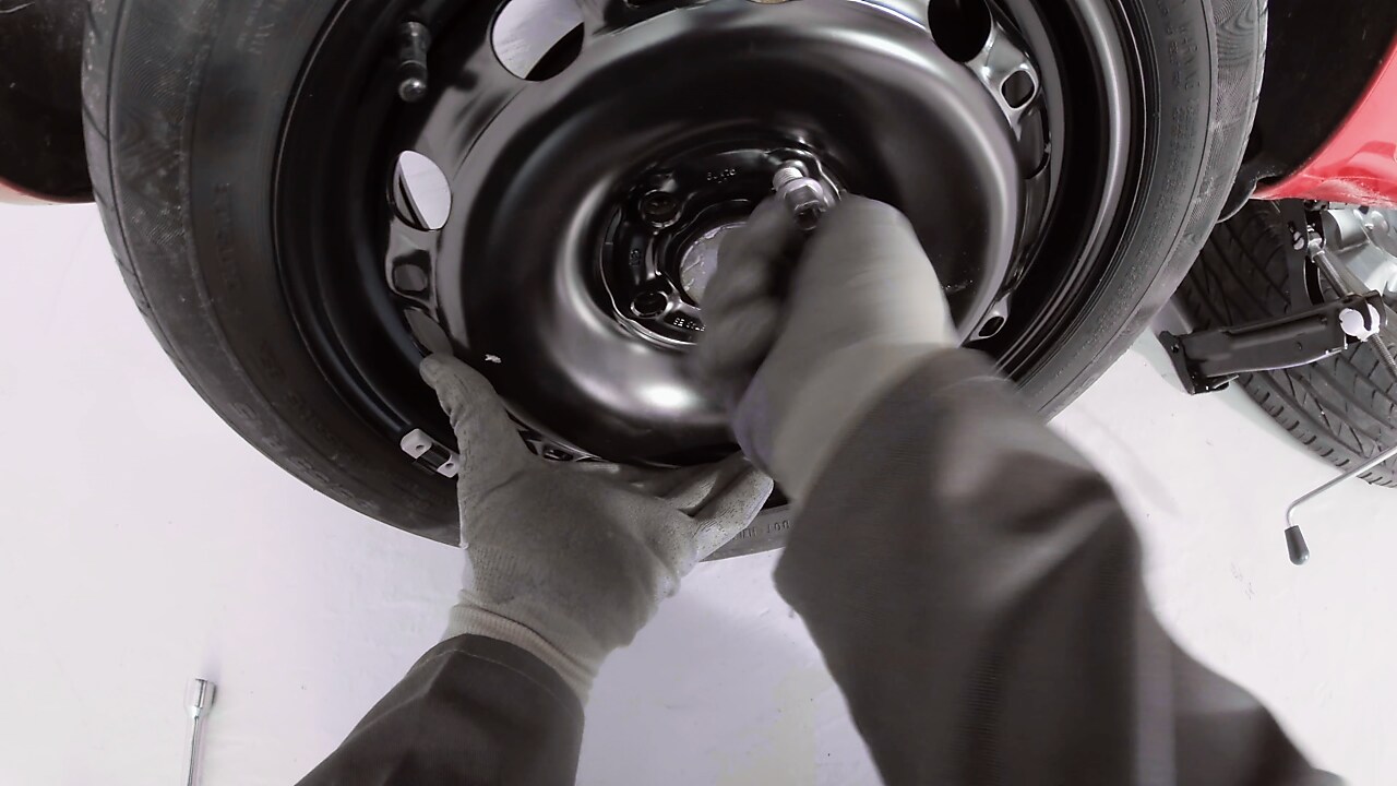 Ręce przykręcające śruby koła