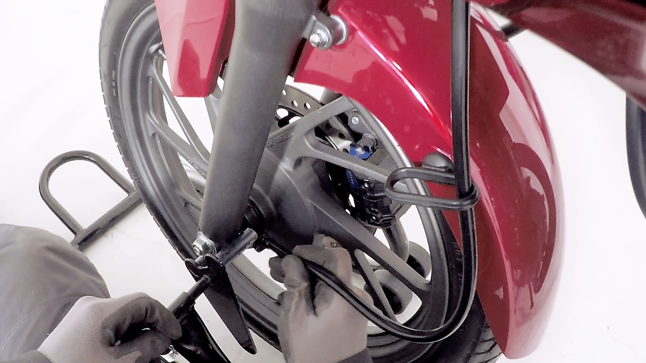 ręce zakładające nową oponę w motocyklu