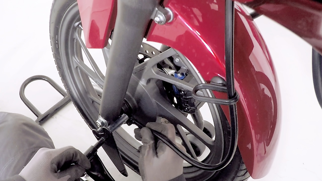 ręce zakładające nową oponę w motocyklu