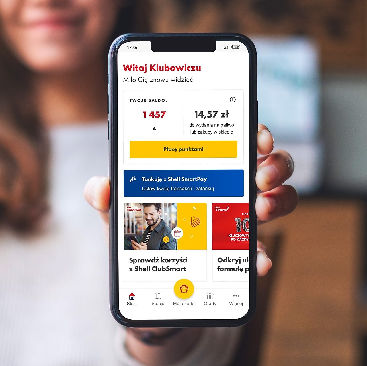 Zdjęcie przedstawiające zadowolona kobietę pokazującą aplikację Shell ClubSmart w telefonie 